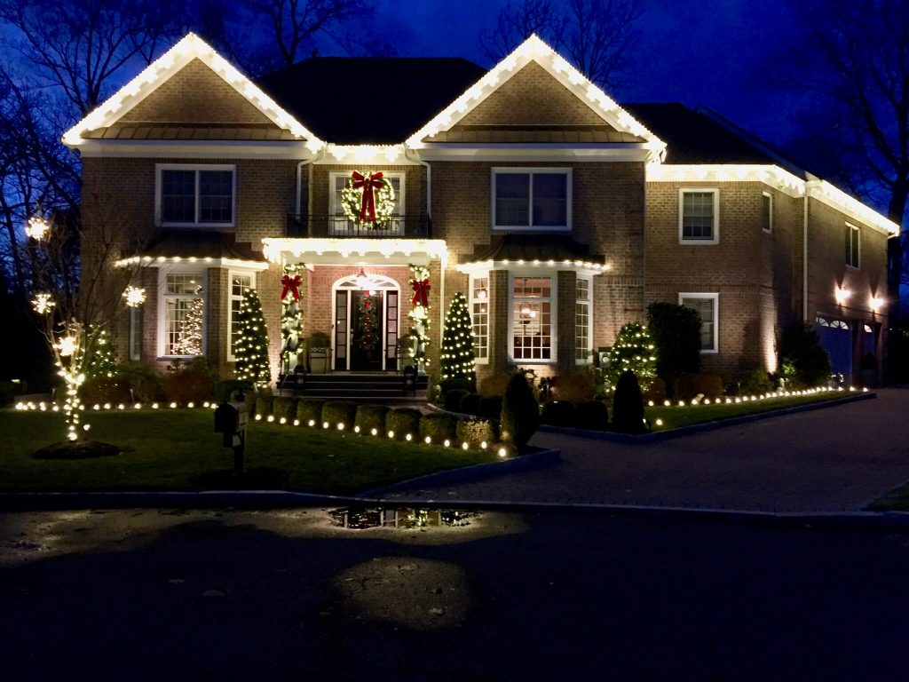 Holiday light installation on a Ridgefield CT home featuring illuminated rooflines, wreaths and landscape lights